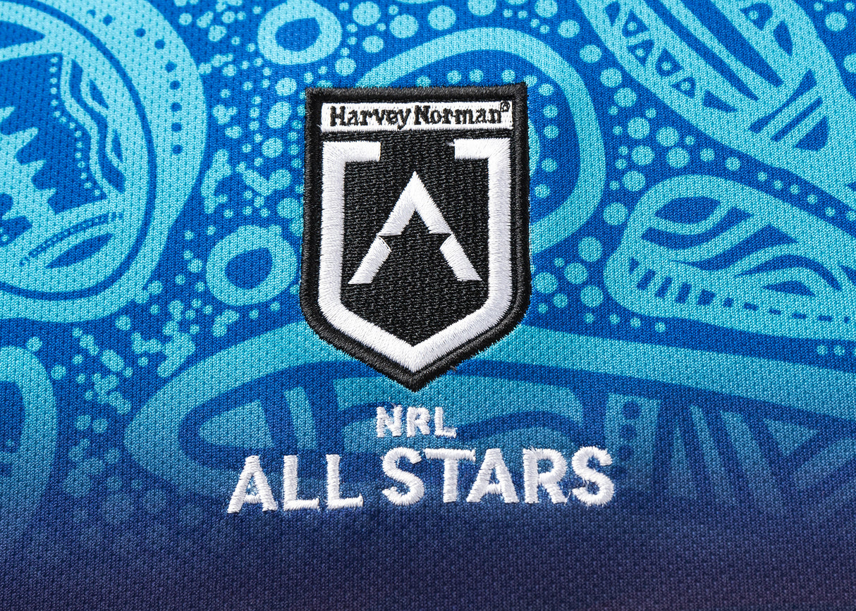 Close-up of an NRL Indigenous All Stars 25/26 logo on a blue, abstract patterned background, echoing the vibrant design of the Replica Home Jersey by Classic Sportswear.