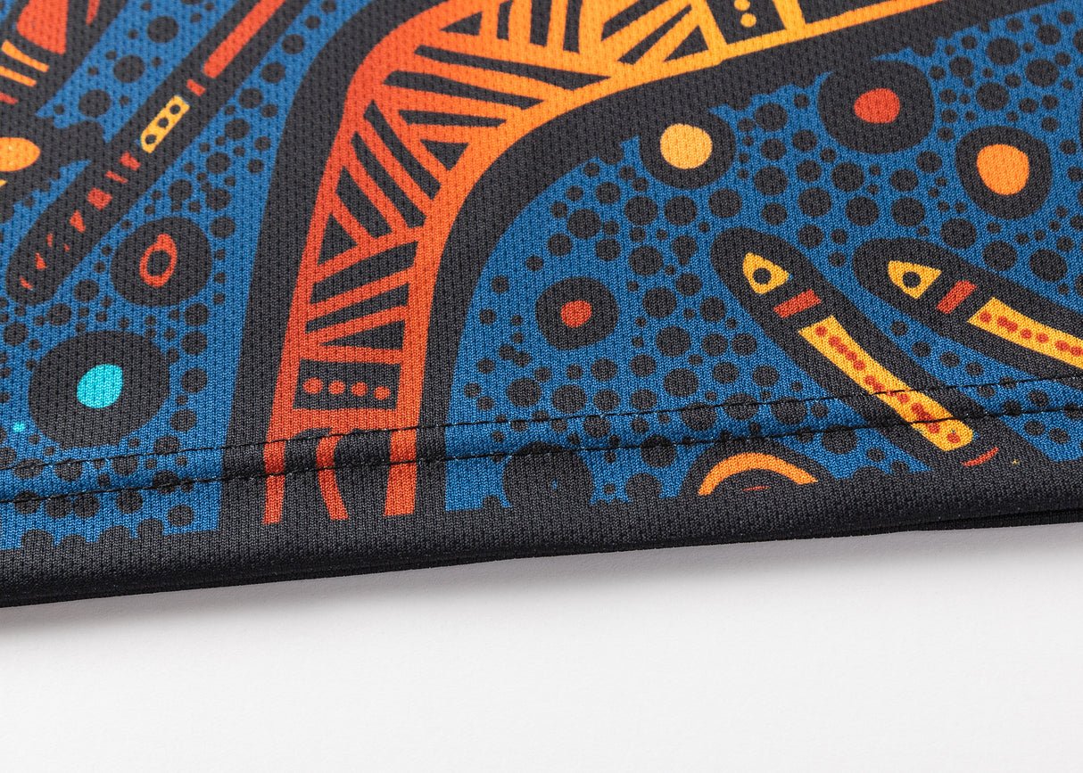 Close-up of Classic Sportswear fabric echoing the NRL Indigenous All Stars 25/26 Replica Home Jersey, featuring abstract blue, orange, and yellow shapes with lines and dotted accents.