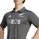 A person wearing an All Blacks Training Jersey by adidas, showcasing the Adidas and INEOS logos, with a striking silver French Fern design on the chest and featuring AEROREADY technology for optimal comfort.