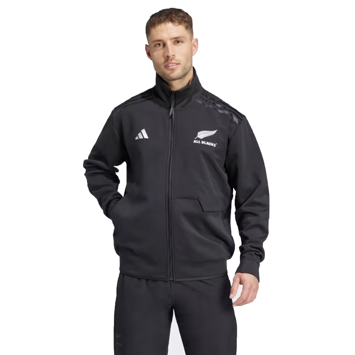 A person in a black All Blacks 24/25 Anthem Jacket by adidas, featuring Adidas rugby's AEROREADY technology, stands against a white background.