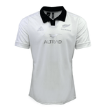 This All Blacks 24/25 Away Supporters Jersey by adidas is a white rugby masterpiece with a black collar, showcasing team logos and "ALTRAD" on the front. It's designed by adidas and enhanced with AEROREADY technology for ultimate comfort.