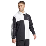 Wearing the All Blacks 24/25 Culture Jersey by adidas, a black and white long-sleeve design with signature three stripes on the sleeves and an adidas logo on the chest, echoing classic All Blacks style.