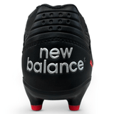 End of black rugby boot with new balance across the heel and red studs on the sole. 