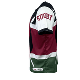 Side view of a Nations of Rugby Kenya Sevens Rugby Flag Jersey by Admiral with a red, white, green, and black color scheme, featuring "RUGBY" on the left sleeve and crafted with VapoDraw technology.