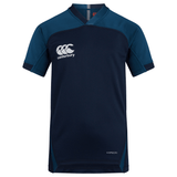 The Canterbury Vapodri Evader Jersey is dark blue with light blue accents and short sleeves, featuring the Canterbury logo and "VAPODRI" text to highlight its moisture-wicking technology for enhanced performance.