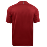 Rear view of a plain red short-sleeve Canterbury Vapodri Evader Jersey with a small gray stripe near the collar, featuring moisture-wicking technology.