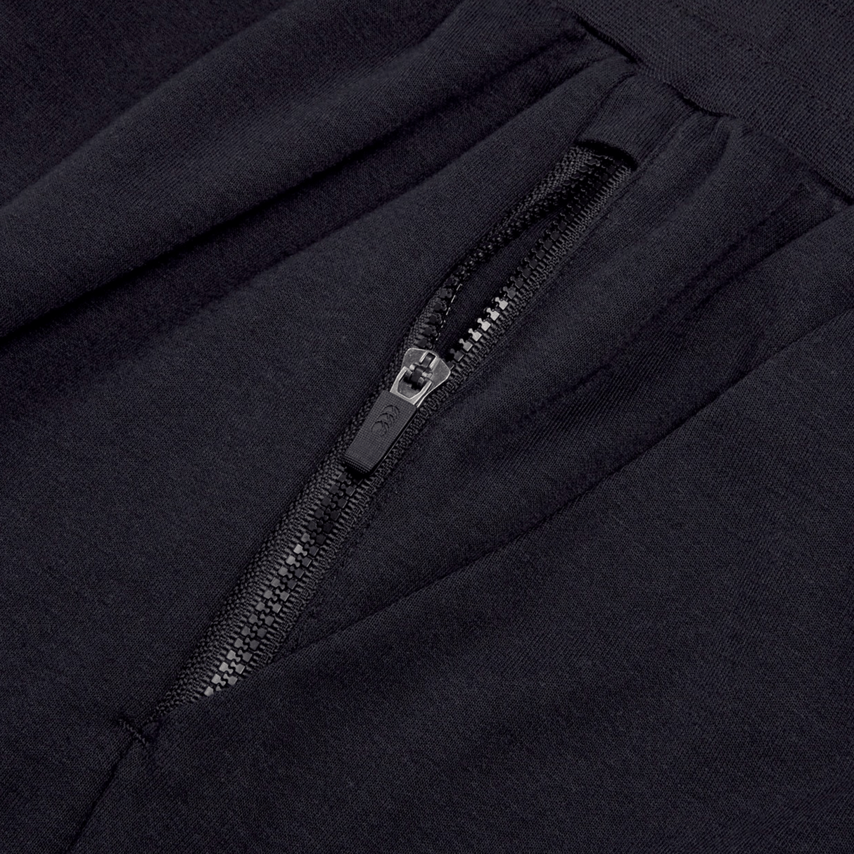 Close-up of the Ireland 24 Fleece Short by Canterbury, featuring a sleek design in black fabric with a zippered pocket in the center, reminiscent of Canterbury rugby shorts.