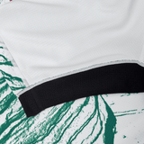 Close-up of a white fabric with a black band on a green and white marbled background, showcasing the elite performance and moisture-wicking fabric akin to the Ireland 24 Alternate Pro Jersey by Canterbury.