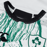 Close-up of the Ireland 24 Alternate Pro Jersey by Canterbury, a white and green rugby shirt featuring a shamrock emblem on the right, a stylized Canterbury logo on the left, and a black collar. Made from moisture-wicking fabric for elite performance.