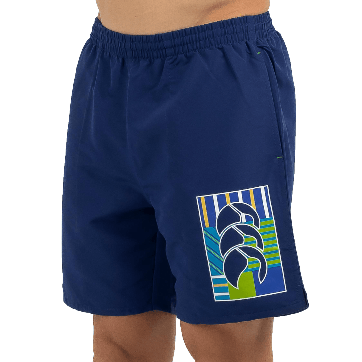 A man wearing a blue swim short from the Canterbury Uglies Tactic Short range with a CCC logo appliqued.