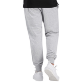 A person is walking away wearing Canterbury Uglies Everyday Taper Leg Pants in light grey with hip pockets, paired with white sneakers and a black top visible at the waist.