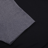 Close-up of lightweight grey fabric highlights the exquisite details of a Women's Canterbury Elite Training Tee, elegantly draped over a black textured surface.