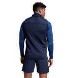 Man in blue athletic wear with a Canterbury Elite Microlite Gilet, viewed from behind, looking to the left.