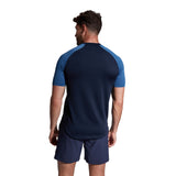 The back view of a man wearing a navy Canterbury Elite Training Tee.