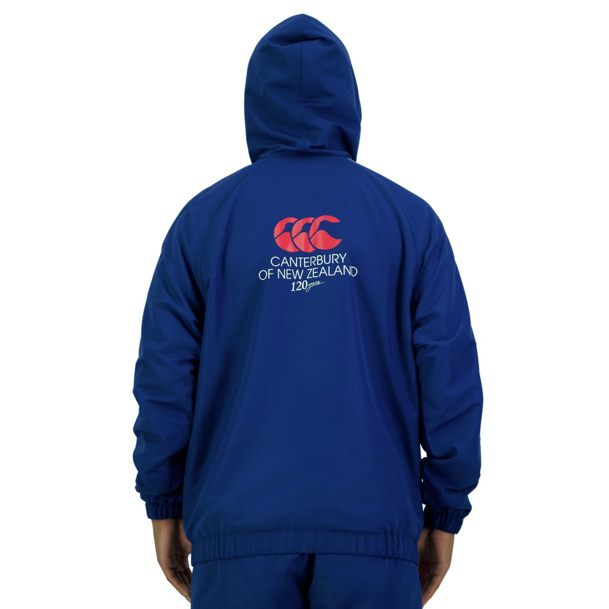 Person wearing the Canterbury Legends Woven 1/4 Zip in blue, featuring "Canterbury of New Zealand 120 years" and a logo printed on the back, effortlessly blending sports casualwear style.