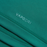 A close-up of the teal fabric highlights the Vapodri Technology, with "VAPODRI" text prominently printed, showcasing visible stitching and wrinkle details. This design is a testament to the Ireland 150th Anniversary Pro Home Jersey by Canterbury's perfect blend of tradition and innovation.