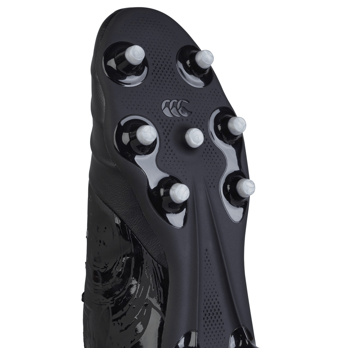 The image displays the bottom of a Canterbury Phoenix Genesis Team FG - Black/Silver Metallic rugby boot, featuring metal studs and a textured sole for improved grip, along with a synthetic leather forefoot tailored for firm ground play.