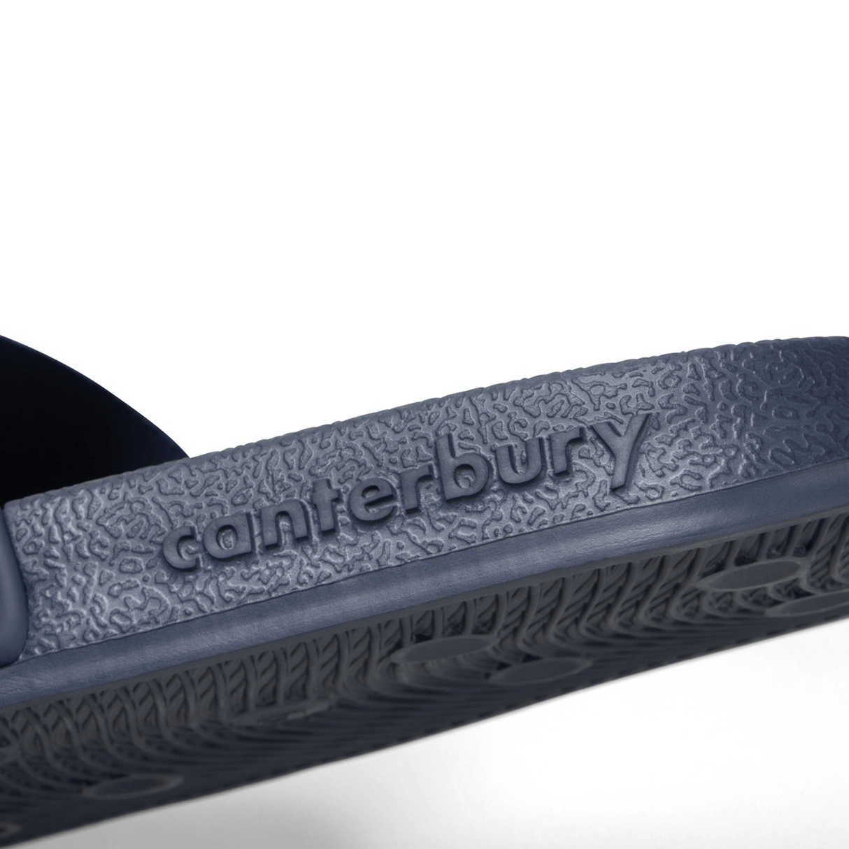 Close-up view of the text “Canterbury” embossed on the textured sole of the navy Canterbury Wide Fit Slide, designed for ultimate comfort.