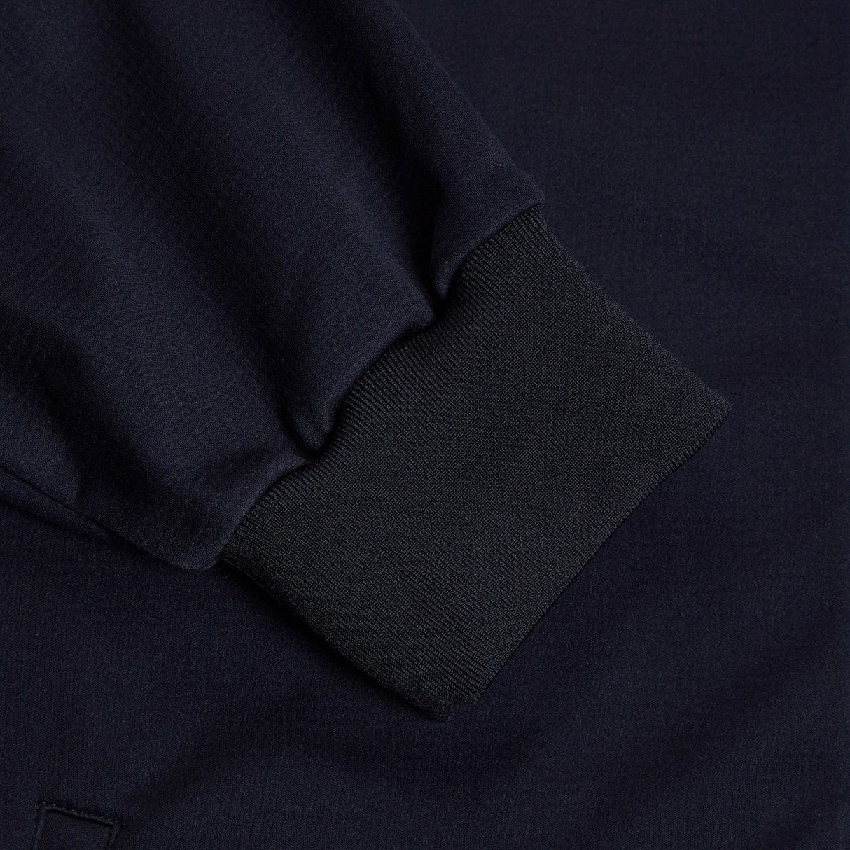 Close-up of a navy blue Canterbury Elite Windstopper Jacket, focusing on the texture and the folded sleeve detail.