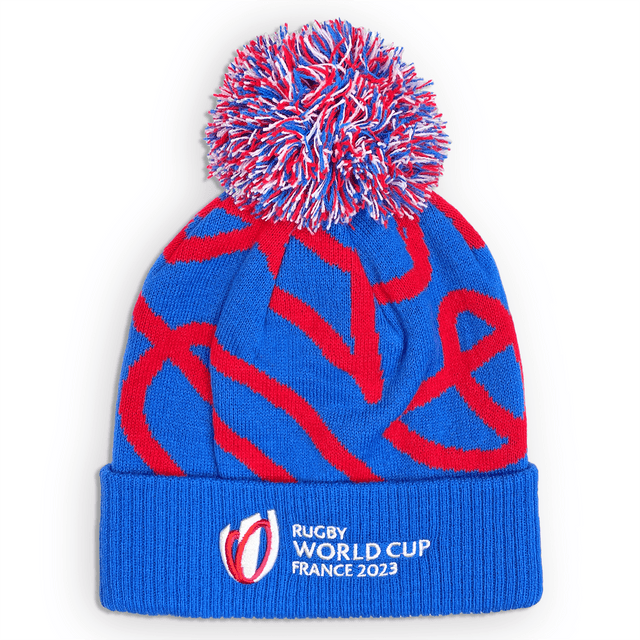 Blue knit beanie with red, white, blue pom pom on top, red swirl design in the center and Rugby World Cup France 2023 embroidered in white on the cuff.