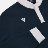 Detail of navy long sleeve polo with white collar, white embroidered Macron symbol and white cuffs.