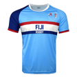 Light blue jersey with round neck and short sleeves. Right shoulder and sleeve in dark blue trimmed in red. Left sleeve in light blue trimmed in red. Fiji partial flags on upper left chest with Fiji Rugby in the center of red and dark blue horizontal lines.