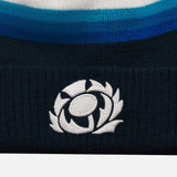 Detail of the white embroidered Scotland symbol on the navy knitted cuff of the hat.  