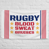 White brick wall with a white flag with red and blue stripes, yellow stars, and 'RUGBY, BLOOD, SWEAT, BRUISES' inscription