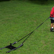 Athlete Wearing Harness and Vest Pulling Drag Sled