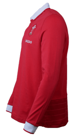 Side view of the Wales Long Sleeve Home Polo 22/23 by Macron in red, with white cuffs and collar. This jersey, reminiscent of a classic rugby shirt, features a logo on the chest and the word "Cazoo.