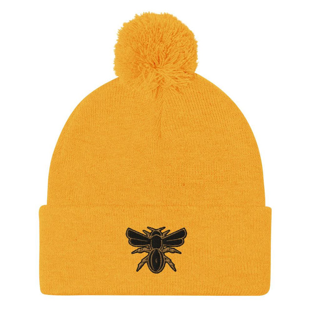 A Rugby Hive Gold Pom-Pom Beanie with a black bee on it.